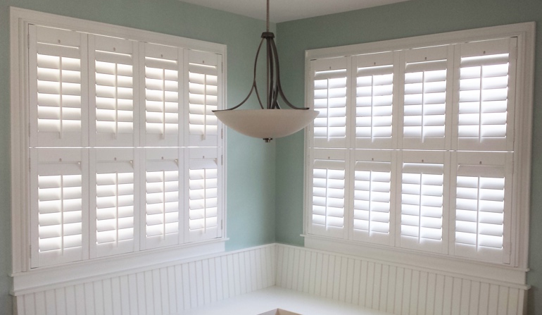 Pastel green wall in Miami kitchen with shutters.